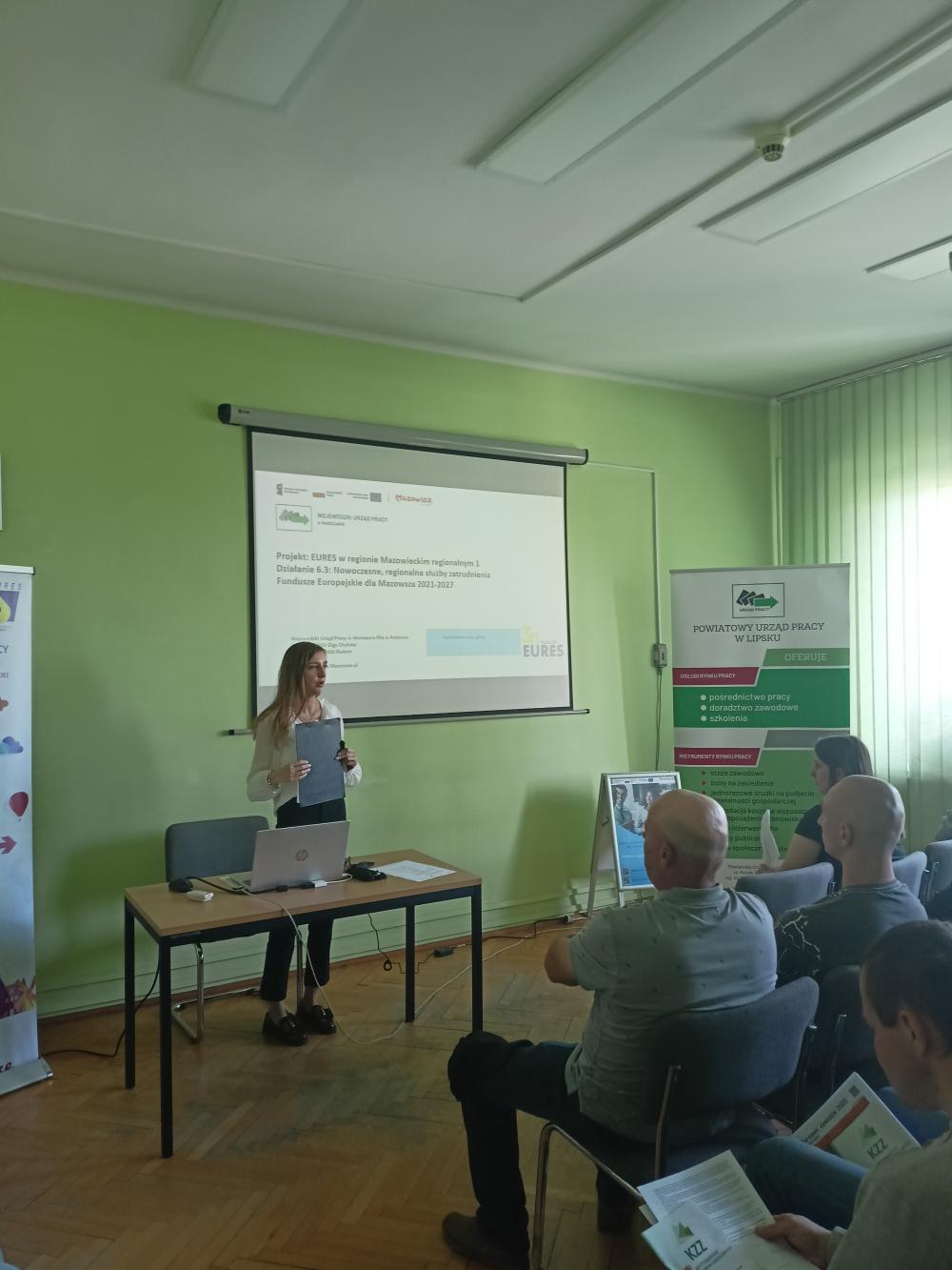 Zdjęcie przedstawia Panią Olge Chylicką Asystenta Eures, Wojewódzkiego Urząd Pracy w Warszawie Filia  w Radomiu oraz uczestników spotkania.