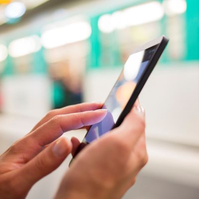 Grafika przedstawia osobę korzystającą ze smartfona